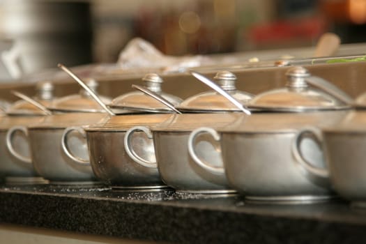 Tin sugar bowls in a restaurant standing in a row, ready to be used