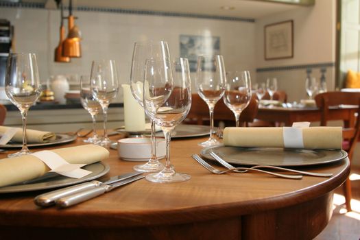 Table setting in a restaurant (shallow DOF, focus on the glasses in front)