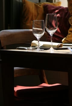 Table in a bistro set by the window while sunlight streams in on one side
