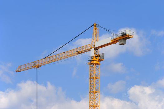 Yellow construction crane on a sky background.