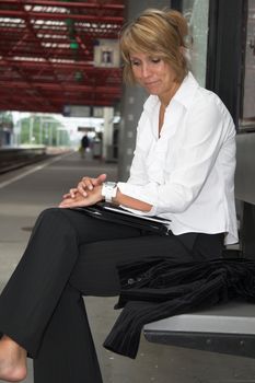 Businesswoman pulling an irritated face while waiting for the train