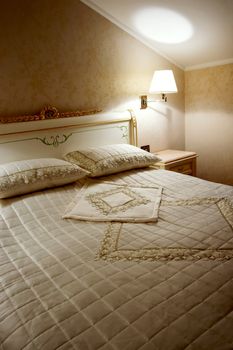 Bed, lamp and bedside-table in a hotel room