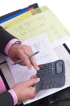 Hands of a businessman making calculations on the costprice of basewage on his calculator (text and numbers are actual costcalculations in dutch and english. No companynames showing)