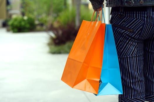 A woman shopping in a mall carrying shopping bags