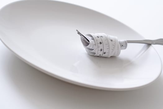 Fork with measuring tape on a plate