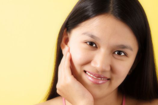 A portrait of a smiling pretty woman with yellow background