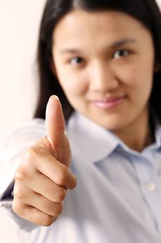 A businesswoman with her thumbs up (focus on thumb, shallow depth of field)