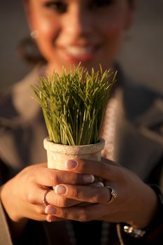 Shallow focus shot of woman holding plastic grass in pot