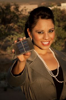 Pretty young woman with small solar panel in hand