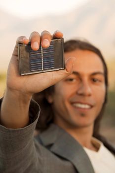 Handsome young mixed race man with small solar panel