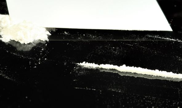 Cocaine and lines (flour) on a black reflective surface