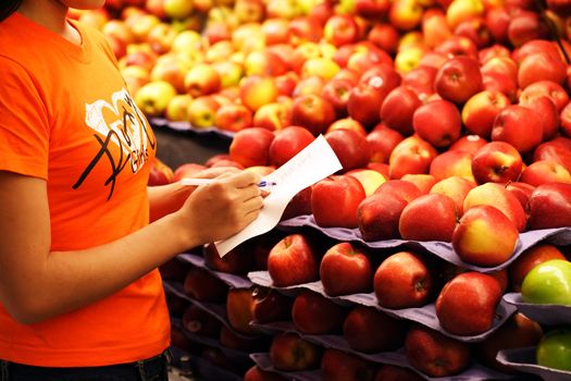 A woman shopping for apples at a grocery store