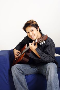 A handsome man playing a guitar