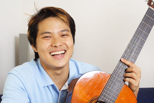 A handsome man holding a guitar