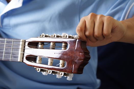 A guitar player tuning his guitar