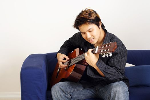 A handsome man playing a guitar