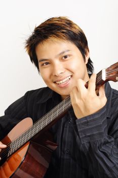 A handsome man playing a guitar