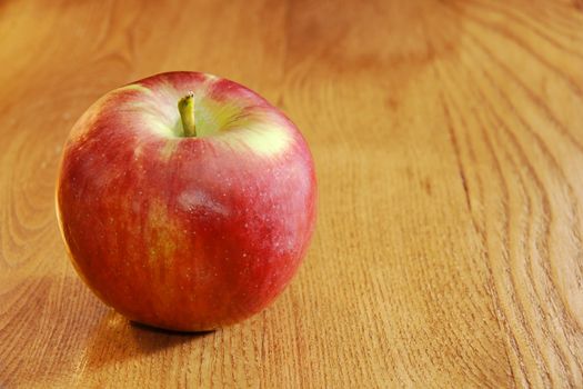 Healthy food: bright red cortland apple on wooden table.