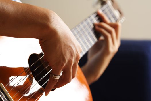 A close up shot of a strumming guitar player