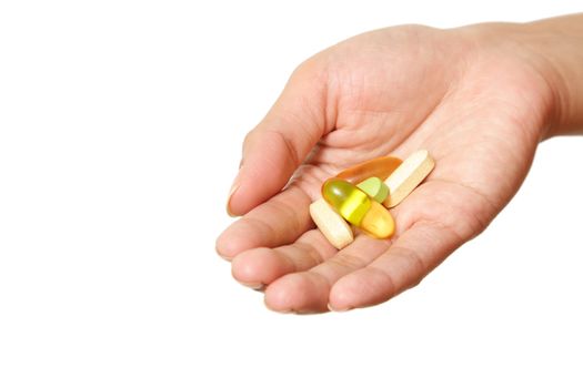 A hand holding multiple vitamins