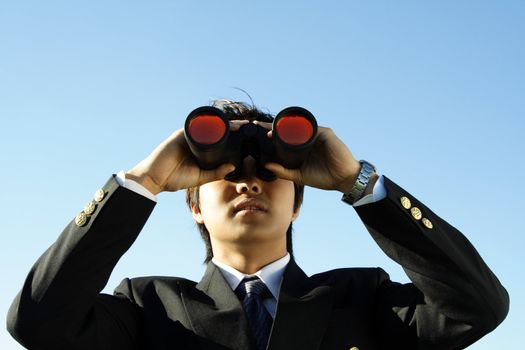 Businessman looking through binoculars, can be used for vision/prospects metaphor