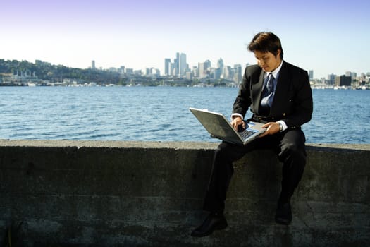 Businessman working on laptop at a park