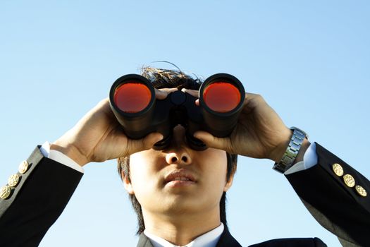 Businessman looking through binoculars, can be used for vision/prospects metaphor