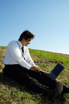 A businessman working on his laptop outdoor