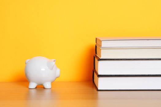 A piggy bank and a stack of books, can be used for "saving for college" design