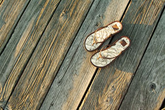 A pair of sandals on a boardwalk