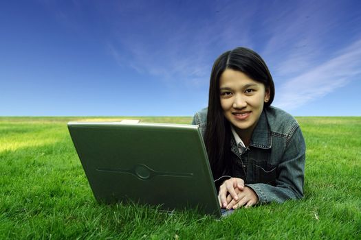 A college student with laptop in a park
