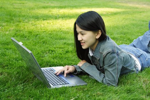 A girl with laptop at a park