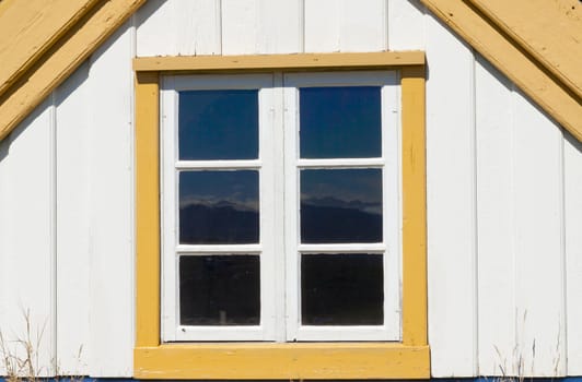 Old wooden white wall, small window. Iceland.