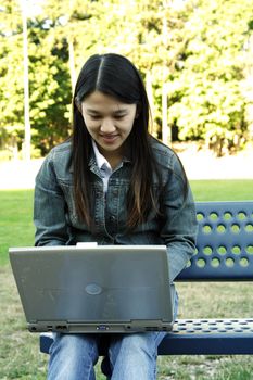 A girl working with her laptop in a park