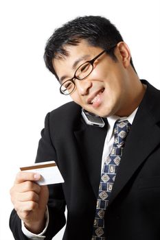 A businessman talking on the phone while holding credit card