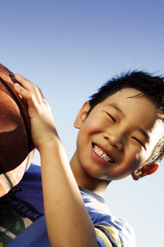 A happy boy holding a basketball