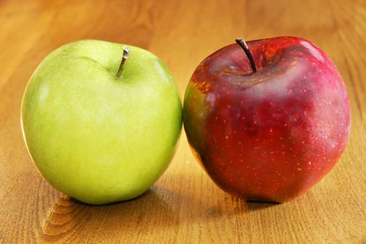 Healthy choices: green granny smith and red delicious apples on top of wooden kitchen table.