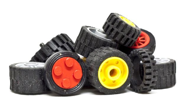 Pile of toy wheels and tires on white background with natural shadows