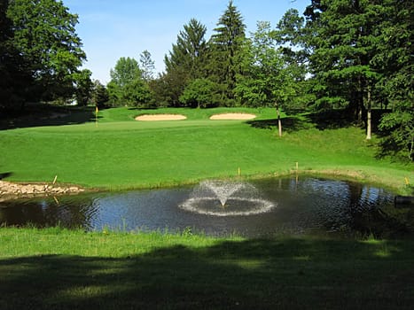 A photograph of a golf course in the afternoon.