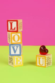 Childrens blocks spell the words love you with bright colors.