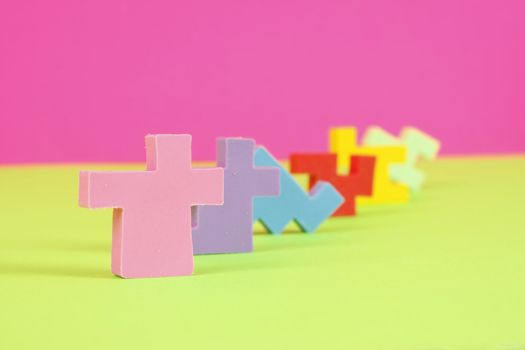 Colorful eraser puzzle pieces in a row with a pink and green background.