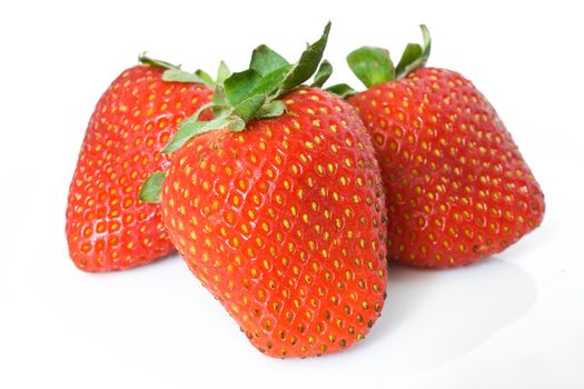 closeup of three ripe strawberries isolated on white background