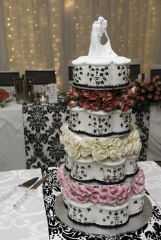 Multi layered wedding cake with bridal figurines and fairy lights