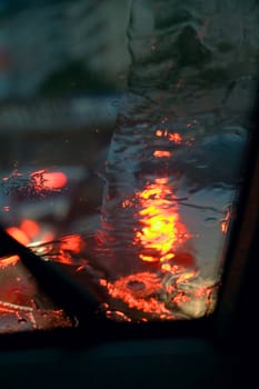 raindrops on the car glass in the light of lamps