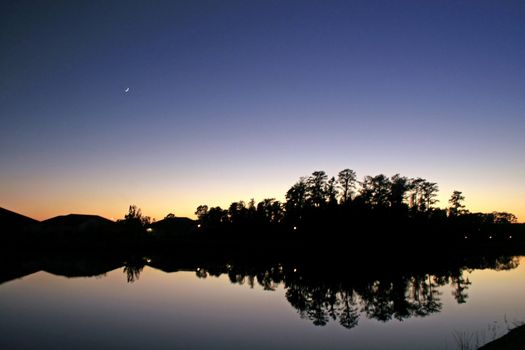 A Sunset, Moon, Trees, Lake and Silhouettes