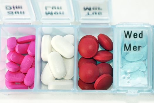 French, english and braille pill box organizer dispencerwith colorful drugs.