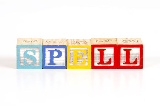 Childrens colorful blocks spell the word spell.