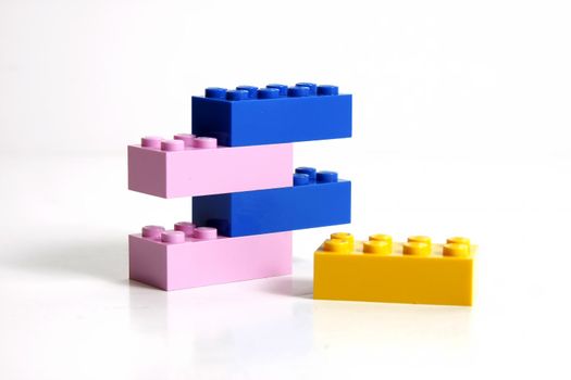 One yellow block and a stack of blue and pink ones.