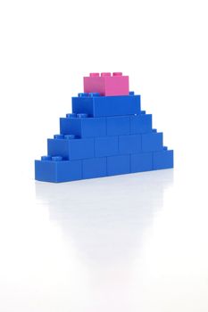 Pink block on top of a blue tower indicates womans strength.