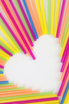 A heart made from colorful straws on a white background.